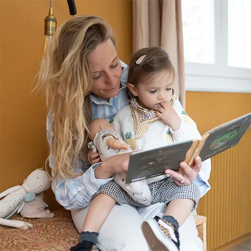 Une baby-sitter et une enfant qui lisent