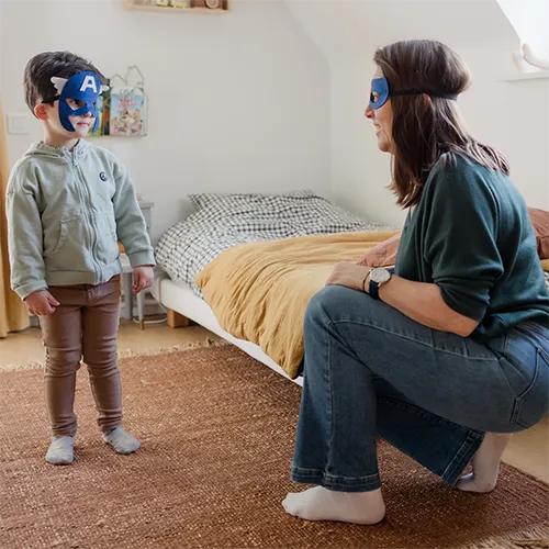 Une baby-sitter et un enfant avec des masques de super-héros