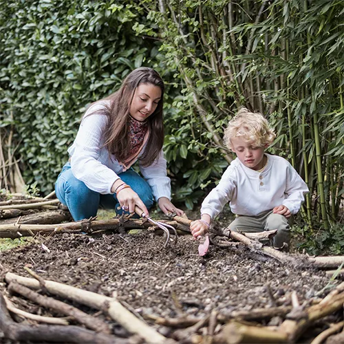 Une baby-sitter et un enfant qui jardine