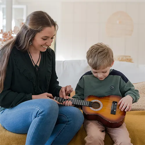 Une baby-sitter et un enfant qui jouent de la guitard
